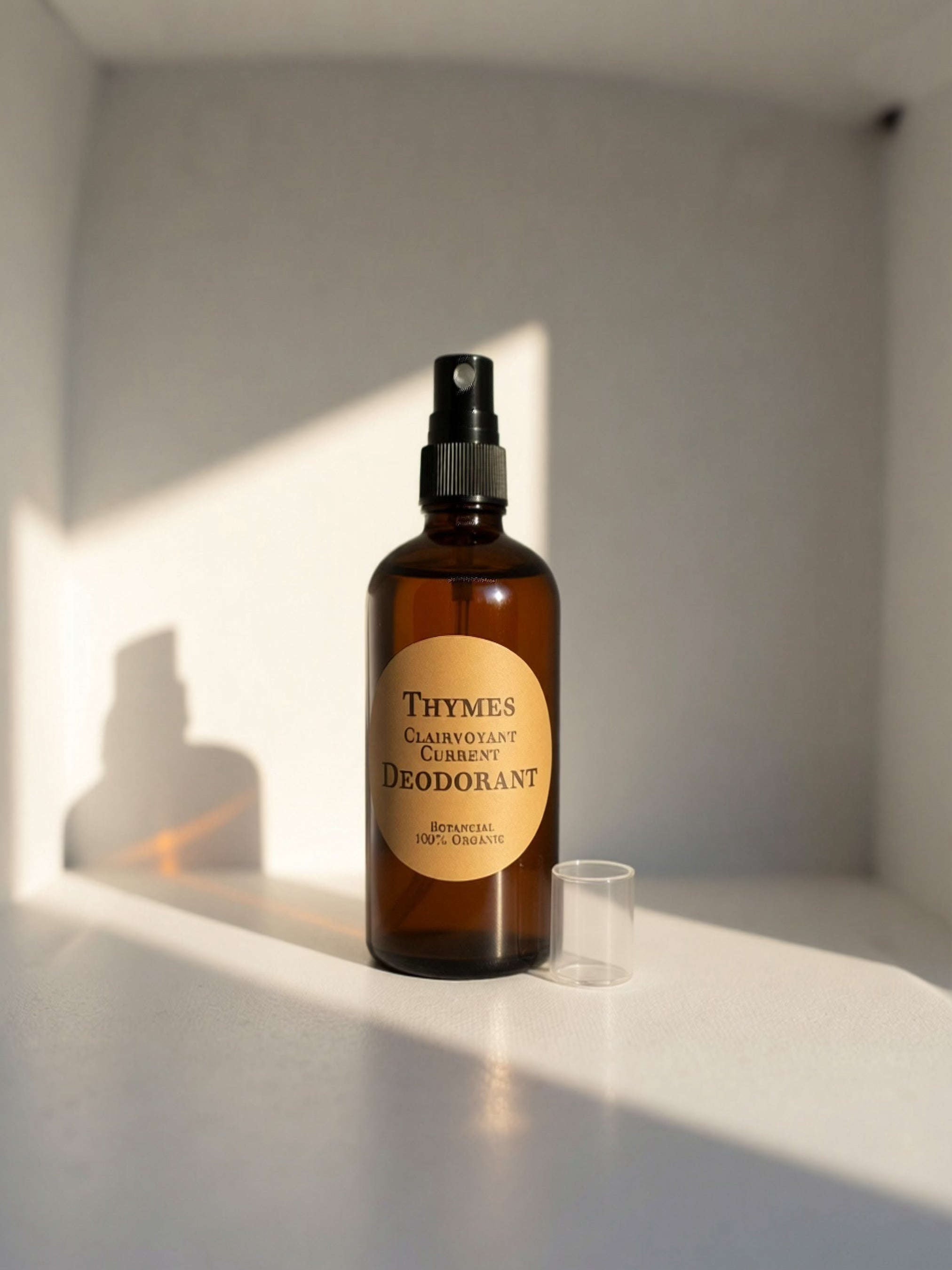 Thymes Clairvoyant Current Deodorant spray bottle with a clear cap on a white surface