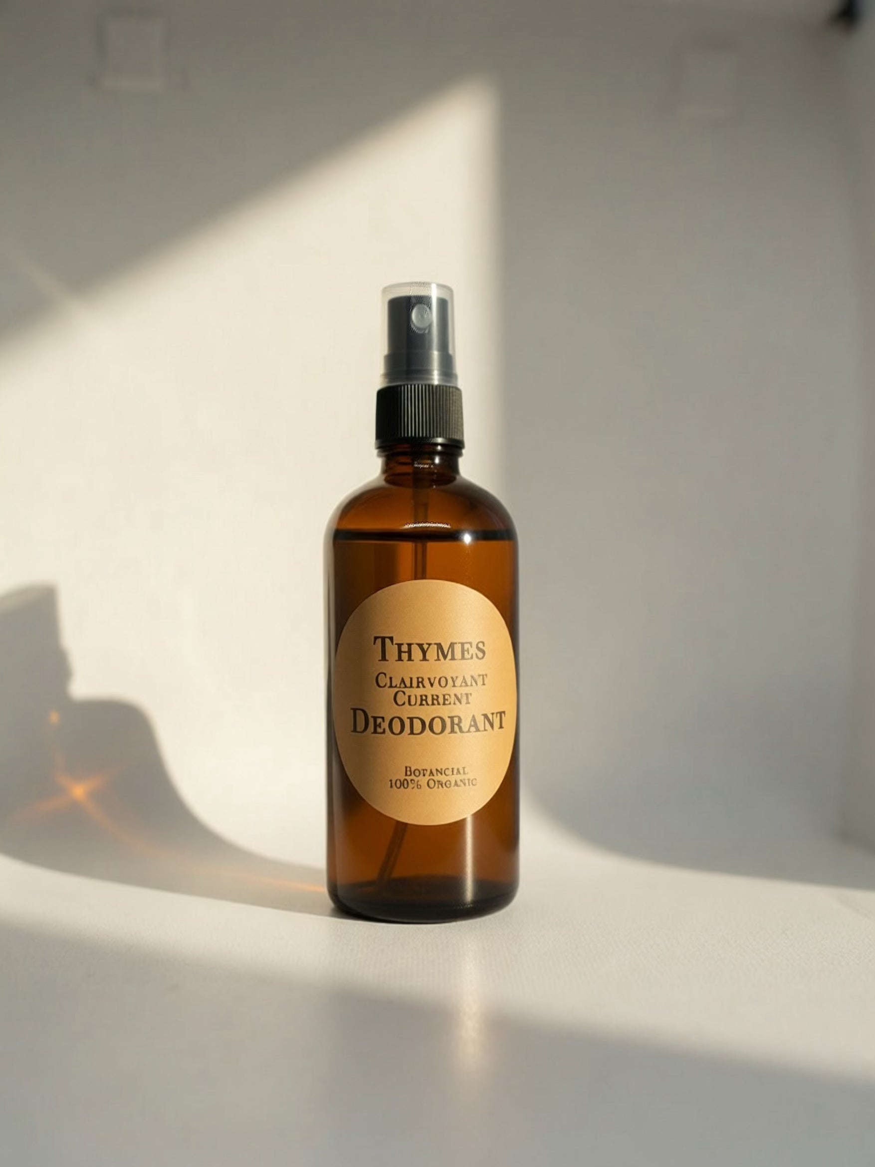 Amber glass spray bottle of Thymes All Natural Deodorant on a seamless white background
