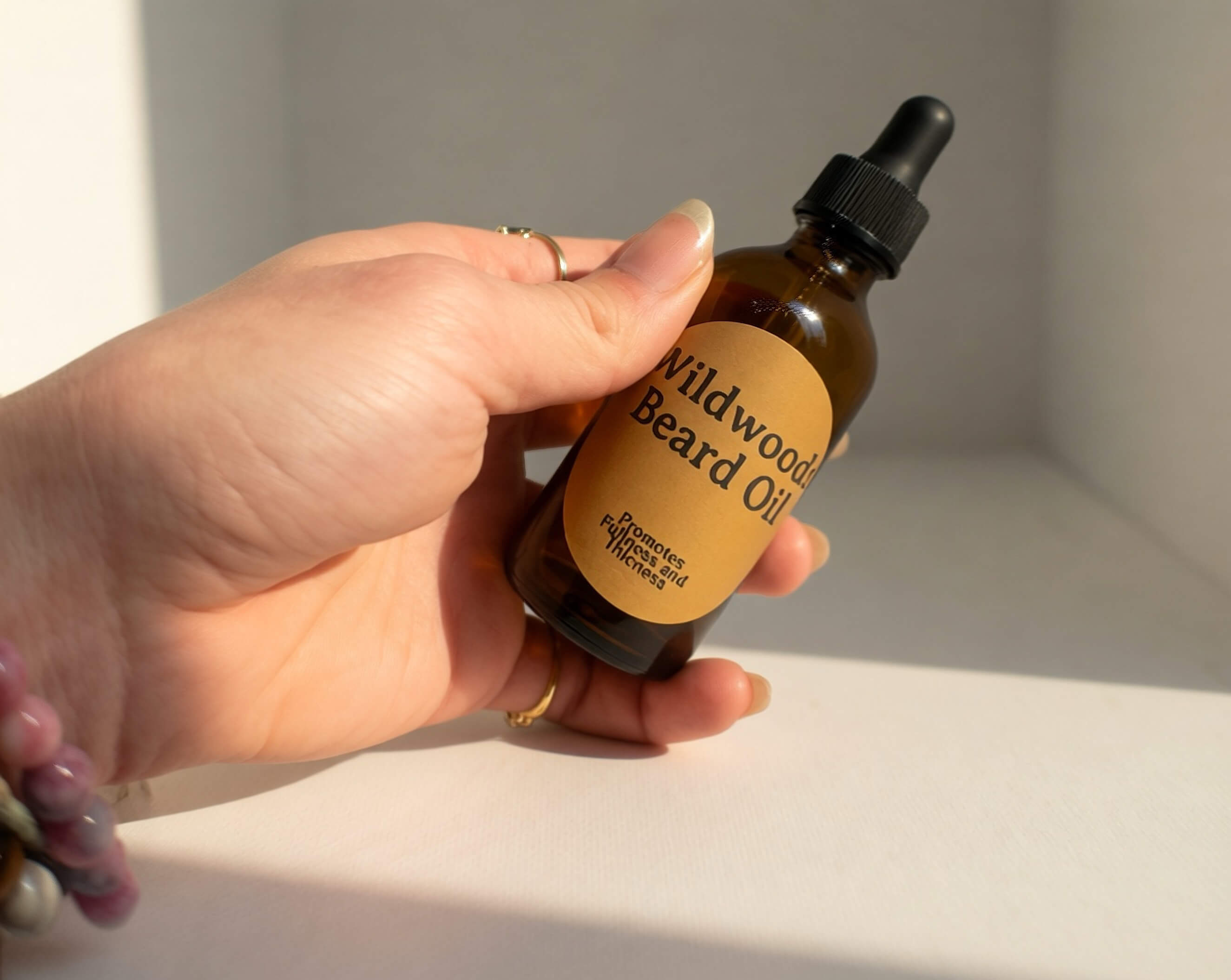 Wildwoods Beard Oil for itchy skin being held in hand with bright, sunny lighting